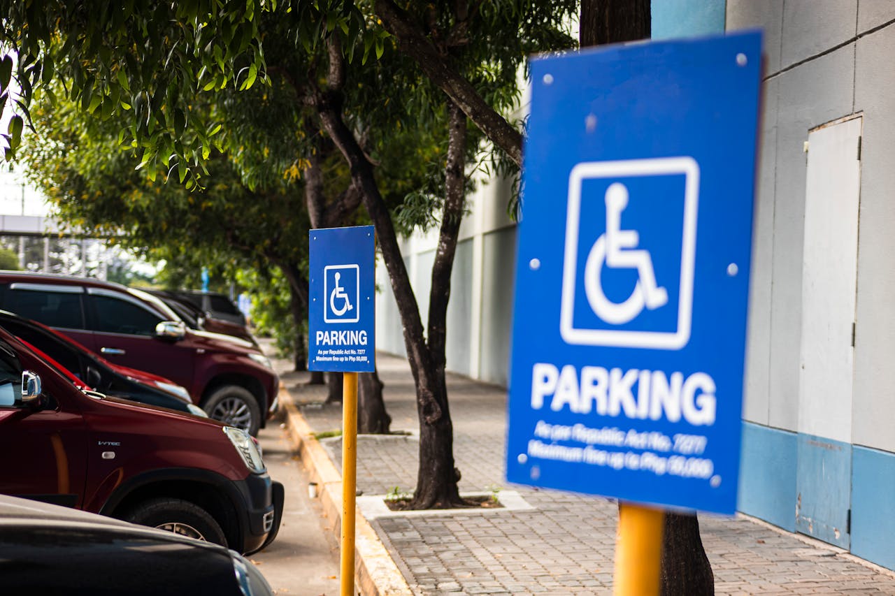 our-story Close-up of a blue disabled parking sign in a city street, highlighting accessibility.